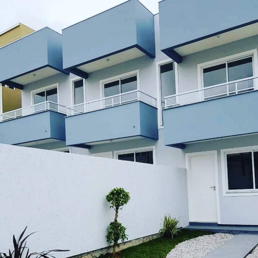 Sobrados geminados entregues, com fachada em azul e branco